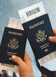 two people are holding up their passport cards