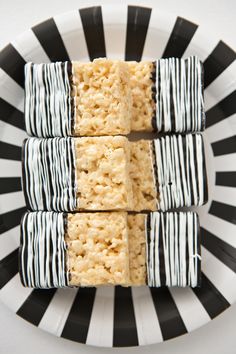 four pieces of rice krispy treats on a plate with black and white striped stripes