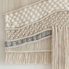 the wall hanging is made out of white yarn