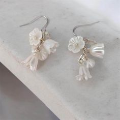 These exquisite white flower earrings are the epitome of bridal elegance, making them the perfect bridal drop earrings for your special day.  Each earring is crafted with delicate, lightweight acrylic flowers that cascade gracefully, creating a beautiful drop effect.  Adorned with subtle crystal accents, these earrings catch the light with every movement, adding a touch of sparkle that enhances their sophisticated charm. Ideal for brides, bridesmaids, or wedding guests, these earrings offer a re White Flower Earrings, Bridal Drop Earrings, Bridesmaid Presents, White Flower Earring, Teacher Graduation, Gift For Bridesmaids, Bridal Earrings Drop, Present For Her, Bridal Elegance