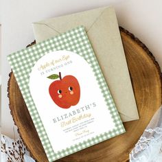 an apple themed birthday party is set on top of a wood slice with lace and paper