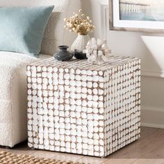 a white couch sitting next to a table with vases on it