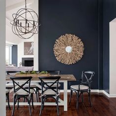 a dining room table with chairs and a chandelier hanging from it's ceiling