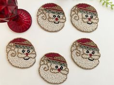 four christmas coasters with santa's face embellished on the front and back