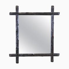 a wooden frame mirror hanging on a wall next to a white wall with a cross in the middle