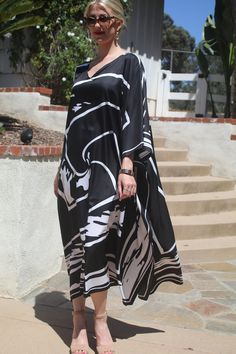 Striking black and white designer print silk caftan is a caftan that will take you from casual to dressy for any occasion.  With it's  modern, abstract design, it is a smart choice.   One size.  Fits many sizes small to X-large.  It measures 52 inches from edge to edge, 104 inches around the body.  The side seams are 6 inches from the edge giving 80 inches around the body and a beautiful, flowing look.  The length is 51 inches.  Machine wash on a short, delicate cycle or hand wash. Chic Black Maxi Dress With Abstract Print, Chic Black V-neck Kaftan, Black Maxi Dress With Abstract Print, Black Beach Dress With Abstract Print, Black Printed V-neck Kaftan, Black Printed Tunic Kaftan, Black Abstract Print Dress For Vacation, Black Dress With Abstract Print For Vacation, Black Summer Kaftan With Kimono Sleeves