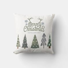 a white pillow with christmas trees and the words merry christmas written on it in green