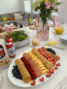 a white plate topped with lots of fruit and veggies on top of a table