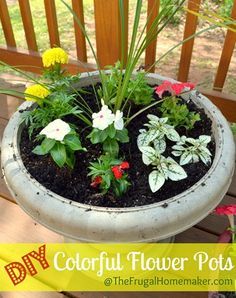 a planter filled with flowers sitting on top of a wooden deck