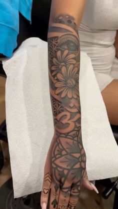 a woman's arm with tattoos on it, and her hand in the middle