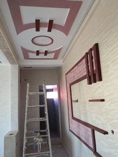 a ladder is in the middle of a room that has been painted pink and white