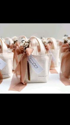 small bags with ribbons and tags on them are sitting next to each other in rows