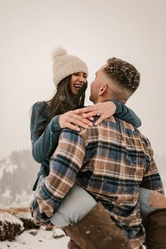 a man carrying a woman on his back in the snow