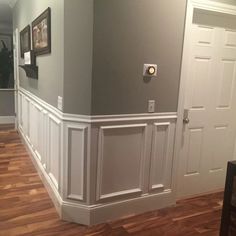 an empty room with hard wood floors and gray walls