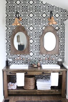 the bathroom is decorated with black and white wallpaper, two round mirrors above the double sink