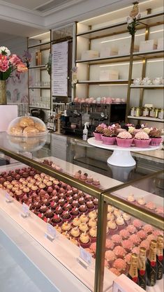 a display case filled with lots of different types of cupcakes and pastries