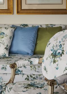 a floral couch with blue and green pillows