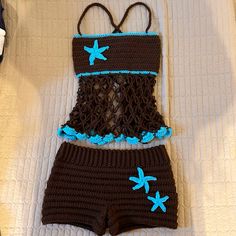 a crocheted swimsuit and shorts are laying on a bed