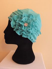 a black mannequin head with a blue flower on it