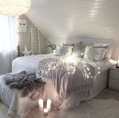 a white bedroom with lights on the ceiling and bed in the corner, next to a window