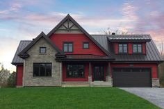 a large red house with two garages on the front and one story above it