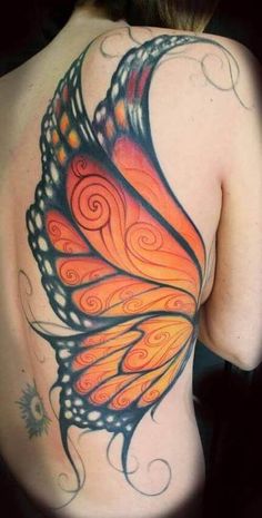 a woman's back with an orange and black butterfly tattoo