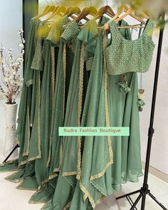 several green dresses hanging on a rack in front of a mirror with the words ruffle fashion boutique