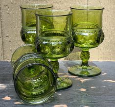 green glassware sitting on top of a wooden table