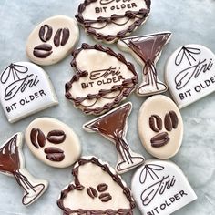 some decorated cookies are sitting on a table with the words bit older written on them