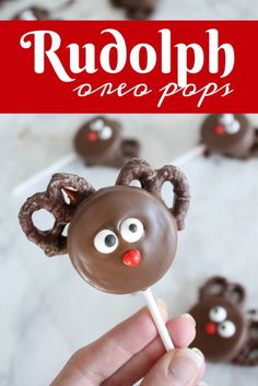 a hand holding a chocolate covered pretzel with reindeer antlers on it and the words rudolph are pops