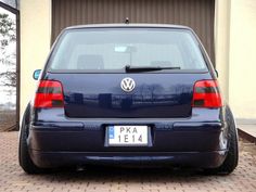 a blue car parked in front of a garage door with the number plate pka 1214 on it