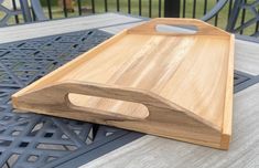 a wooden cutting board sitting on top of a patio table next to a metal grill grate