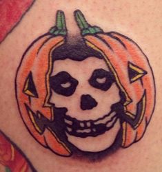 a close up of a person with a tattoo on their stomach wearing a pumpkin costume