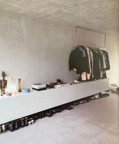 an empty room with shoes and clothes on the shelf