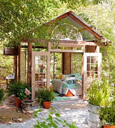 a small garden shed with potted plants in it