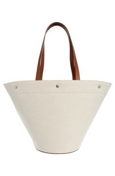 Unbleached canvas made of cotton and linen furthers the casual, go-everywhere appeal of this shapely tote fronted by bold logo lettering. Open top Top carry handles; removable, adjustable crossbody strap Structured silhouette with flat base for stability Textile with leather trim Made in Italy Designer Handbags Cotton Canvas Bucket Bag With Leather Handles, Cotton Bucket Bag With Canvas Lining, Everyday Canvas Bucket Bag, Canvas Tote Bag With Leather Trim, Everyday Linen Canvas Bag, Cream Canvas Bucket Bag, Beige Canvas Bucket Bag With Canvas Lining, Canvas Bucket Bag With Tote Shape, Canvas Bucket Bag Tote With Canvas Lining