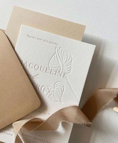 the wedding stationery is laid out on top of each other