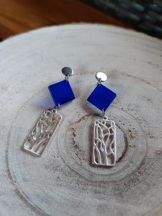 These elegant earrings are handcrafted with blue resin and silver accents, featuring a unique geometric design. Perfect for adding a touch of sophistication and modern style to any outfit, these earrings are ideal for any occasion, from formal events to casual outings. Characteristics: Material: Resin, silver metal Color: Blue with silver details Length: [Specify measurements] Handmade Light and comfortable to wear Perfect for any occasion Careful: To keep your earrings in perfect condition, avoid contact with water and chemicals. Store them in a dry and safe place. Modern Blue Earrings For Party, Trendy Blue Formal Jewelry, Trendy Blue Sterling Silver Earrings, Modern Blue Metal Earrings, Formal Blue Metal Earrings, Blue Metal Earrings For Gift, Modern Blue Metal Jewelry, Elegant Blue Geometric Jewelry, Modern Geometric Blue Jewelry