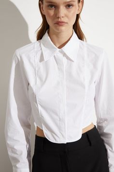 Cropped poplin button-down shirt with tuxedo bib detailing. White satin piping on chest with curved dipped hem. Menswear inspired design with a feminine fit. Style with a pair of Courtney Pants for a put-together street fashion look for day or night. True to size fit for women. Model wears a size XS in this style. Model is 5'9." Tuxedo Shirt, Tuxedo Pants, Shirt Detail, Tuxedo Shirts, Traditional Fashion, Menswear Inspired, White Satin, Fit Style, Shirt White