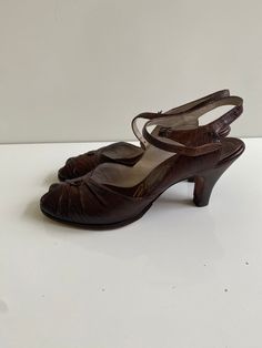 "Vintage 1950s Palizzio New York Leather Sandals Free Shipping These vintage heeled sandals are leather uppers. They are in good vintage condition and have new heel tops and new leather soles. They are tiny. The sole on the inside is just under 9.5\" long and the ball of the foot is 3\" across. The surface of the leather is embossed and could be reptile skin. The brand is Palizzio New York.  I believe them to be a size 6 or 6.5." Retro Leather Open Toe Sandals, Retro Sandals With Leather Sole, Retro Leather Sandals With Leather Sole, Vintage Formal Sandals With 4-inch Heel, Retro Low Heel Heels With Heel Strap, Retro Heels With Heel Strap And Low Heel, Retro Heels With Sculpted Heel And Ankle Strap, Retro Leather Sandals With Low Heel, Retro Closed Toe Sandals With Leather Sole