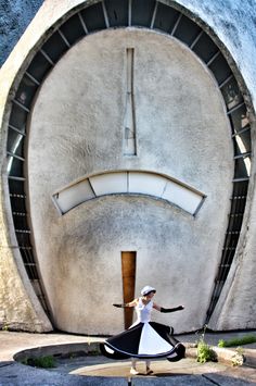 a woman is dancing in front of a building