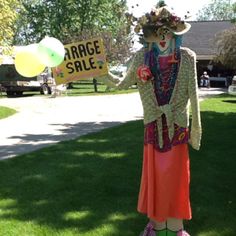 a scarecrow holding up a sign that says race sale