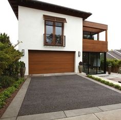 a white house with brown garage doors and windows