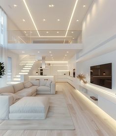 a modern living room with white furniture and wood flooring, along with stairs leading up to the second floor