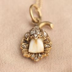 The use of baby teeth (or "milk teeth") in jewelry has nothing to do with mourning. Quite the opposite - during the last centuries, it was worth celebrating if your child survived long enough to lose her first teeth. Thus, the Victorians (a sentimental and not-too-squeamish bunch) commissioned jewelry made from these tiny treasures. This unusual, exquisite pendant features a milk tooth in a detailed floral mounting accented by 14 sparkly rose cut diamonds. Hangs from a new 18" 14k gold chain. Fairy Jewellery, Tooth Keepsake, Victorian Baby, Milk Teeth, Victorian Photos, Teeth Jewelry, Edwardian Jewelry, Tooth Necklace, Baby Teeth