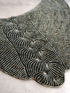 a close up of a piece of cloth with black and white designs on it's side