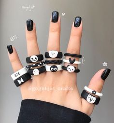 a woman's hand with black and white nail polishes on it, decorated with panda faces