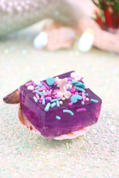 there is a purple donut with sprinkles on it