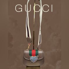 Chic And Classy Gucci Small Linea Totem Bag Comes In Brown Leather, Accented With A Love Heart Diamant At The Front And The Iconic Web Striped. Magnetic Snap Closure. Complete With Detachable Canvas Crossbody Strap. Interior Is Very Clean Comes With Care Cards And Dust Bag. Dimension: L20cm X H15cm X D6cm Strap Drop: 52cm Gucci Leather Shoulder Bag With Logo Strap, Gucci Designer Bag With Logo Strap, Gucci Luxury Bag With Logo Strap, Designer Gucci Bag With Logo Strap, Luxury Gucci Bag With Logo Strap, Gucci Rectangular Bag With Logo Strap, Elegant Brown Bag With Logo Strap, Trendy Gucci Crossbody Bag, Trendy Gucci Crossbody Shoulder Bag