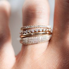 a woman's hand with three different rings on top of her finger and the other ring